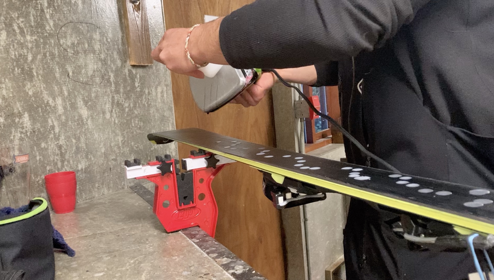 dripping hot wax onto ski base 